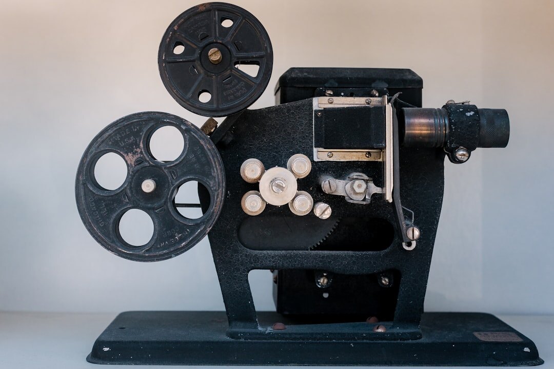 Vintage film reel and cinema projector on a wooden archive table