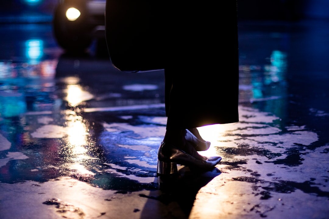 Silhouette of a fashion model walking a runway under dramatic spotlighting